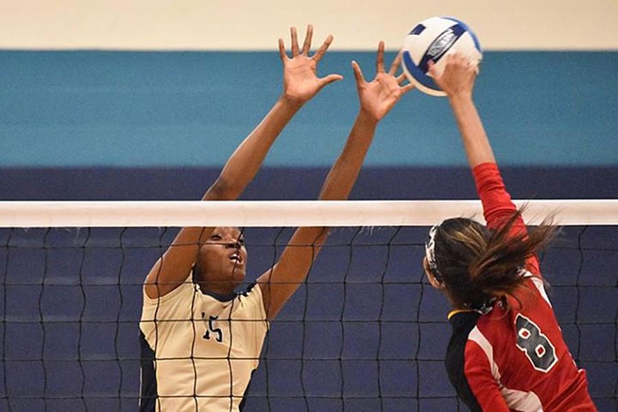 Sharonda Pickering blocks the attempted spike of one of her opponents.