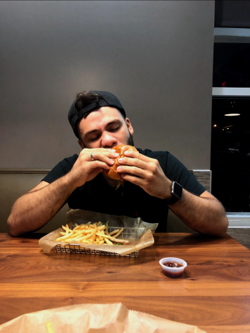 Hawkeye staff writer EliuDaniel Reyes enjoys the first bite of his burger.